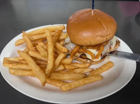 Bourbon Chicken sandwich with white American cheese and crispy onion straws, served with fries