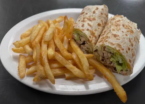 Grilled chicken wrap with lettuce, served with fries.