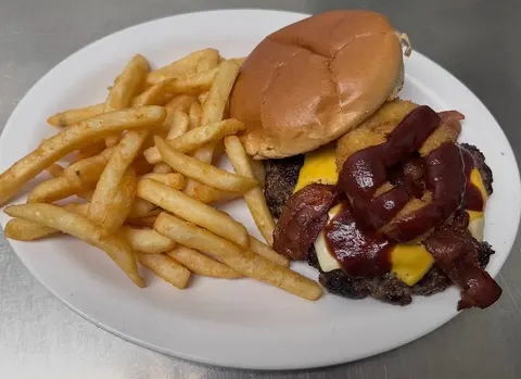 Main Street Burger with cheese, bacon, barbecue sauce, and an onion ring, served with fries